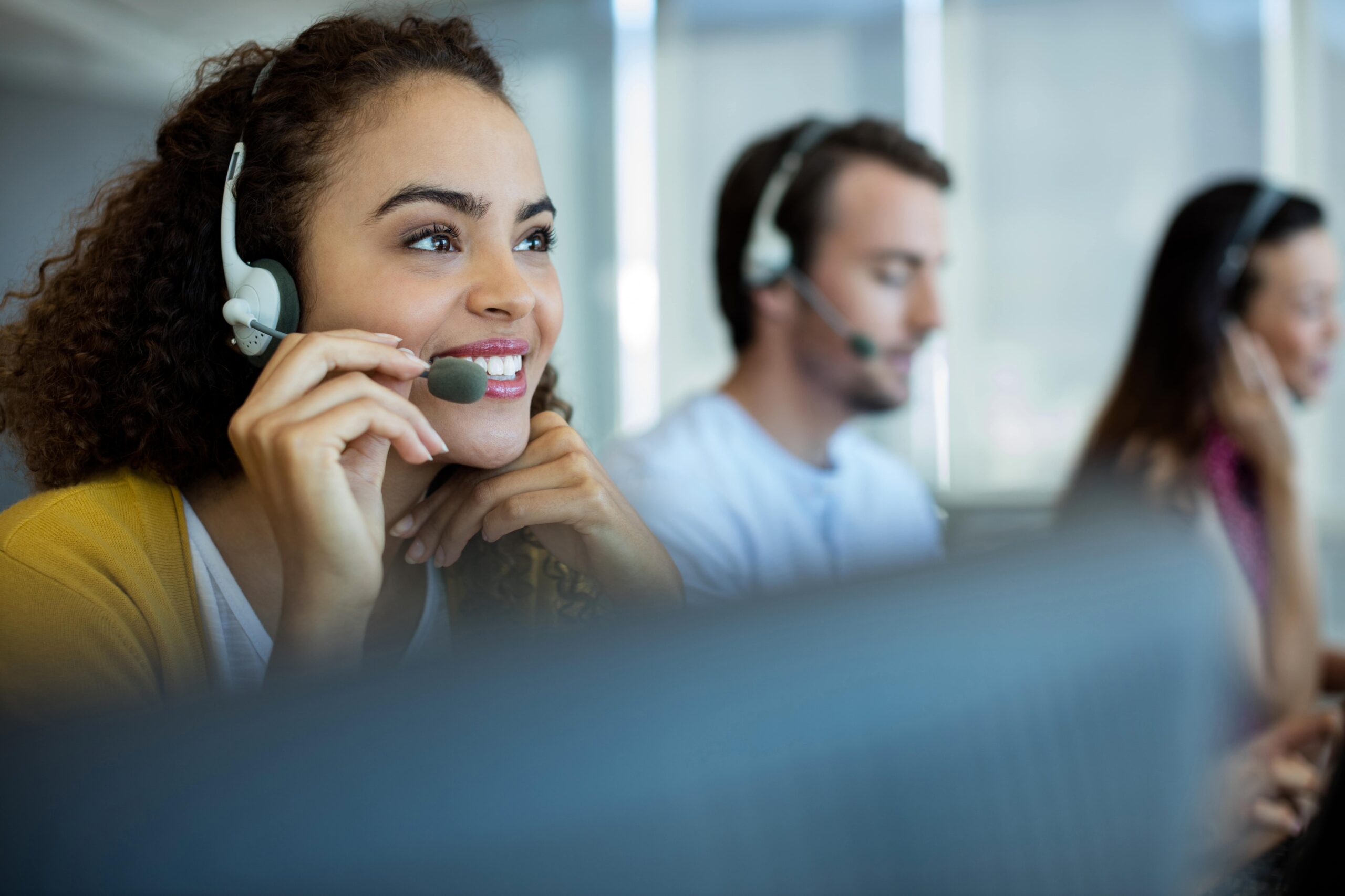 Customer support representative smiling while working with a headset