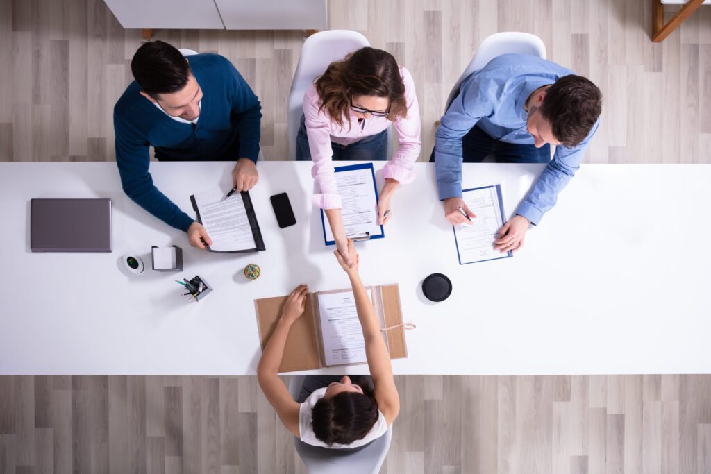 Job interview with handshake, viewed from above.